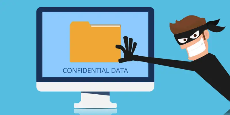 A laptop screen glows red with a black skull and crossbones flag, representing a cyber attack or ransomware threat.