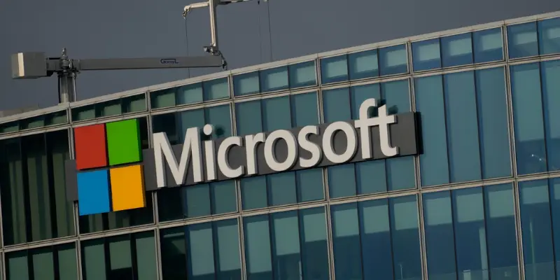 A Close Up Shot Of The Microsoft Logo And Wordmark On The Side Of A Modern Office Building With Glass Windows