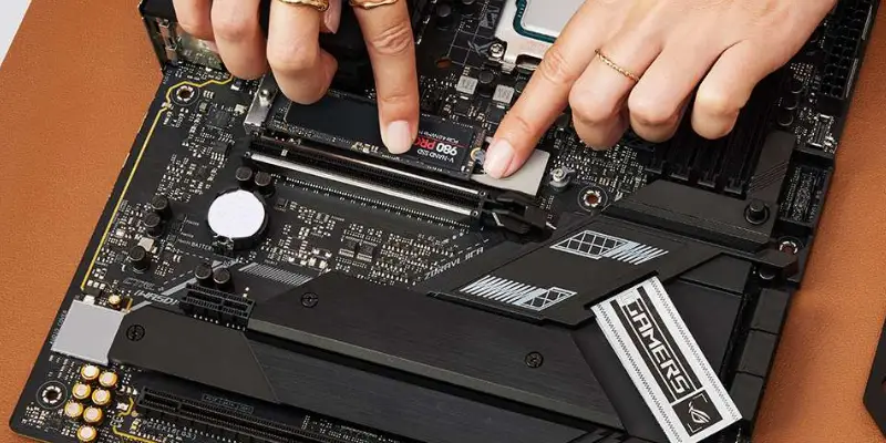 A Hand Pressing The M.2 Ssd Down Into Its Slot On The Motherboard Securing It Before Replacing The Heat Spreader